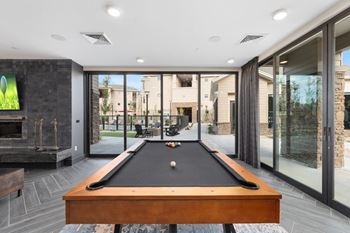 Resident clubhouse with fireplace, co-working spaces, private offices, gaming lounge with billiards table, shuffleboard, arcade games, and full-service coffee bar